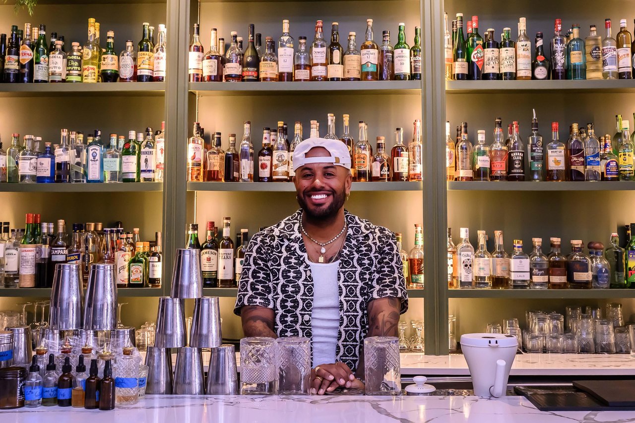 Billy Weathers smiles as he stands behind the bar in the interior of The Contrary.